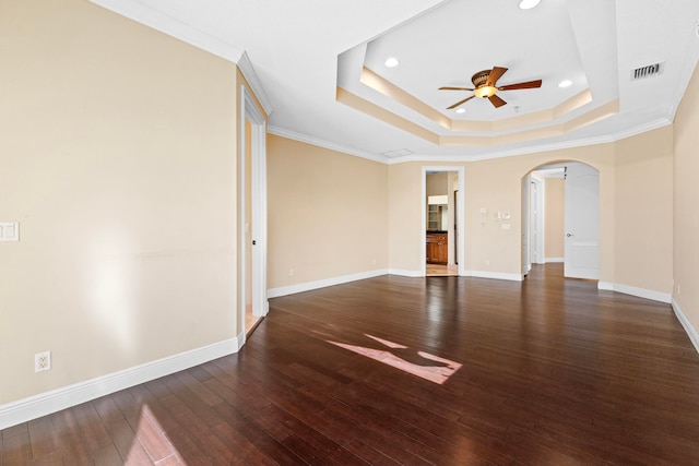 spare room with ornamental molding, ceiling fan, a tray ceiling, and dark hardwood / wood-style flooring