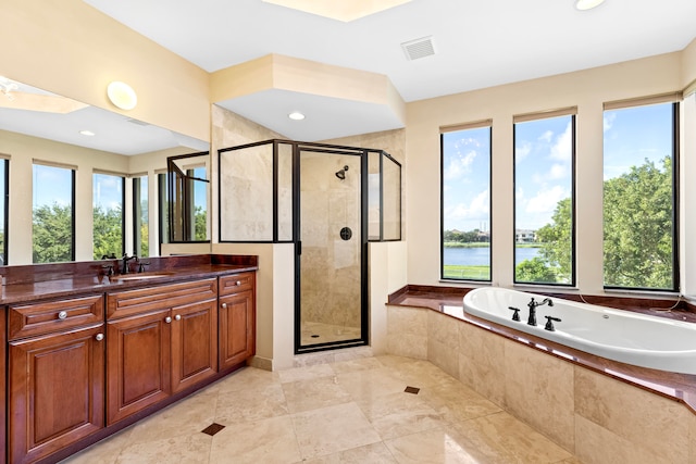 bathroom with vanity, a water view, and separate shower and tub