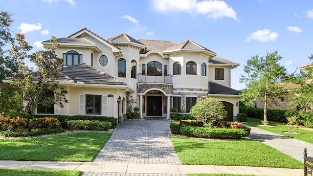 mediterranean / spanish-style house featuring a front yard and a balcony