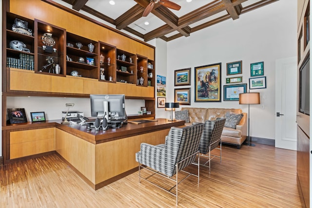 office area with light hardwood / wood-style flooring, ceiling fan, beam ceiling, coffered ceiling, and built in desk