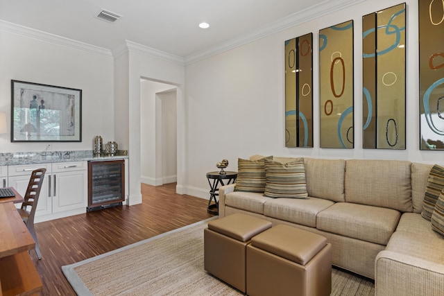 living room with dark hardwood / wood-style floors, bar, ornamental molding, and beverage cooler