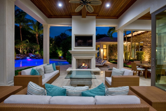 view of patio with ceiling fan and an outdoor living space with a fireplace