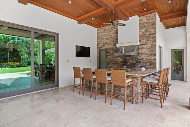 dining space with beamed ceiling, a towering ceiling, and wooden ceiling