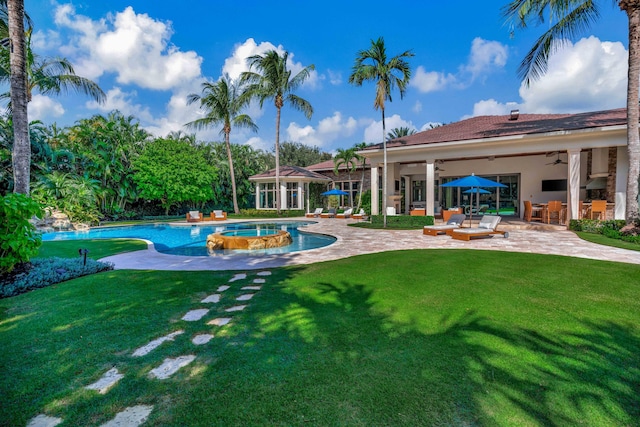 view of pool with a patio area, ceiling fan, and a lawn