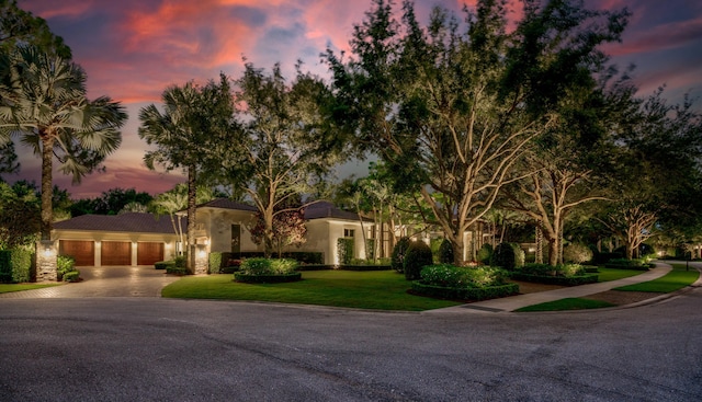 mediterranean / spanish-style home featuring a garage and a lawn