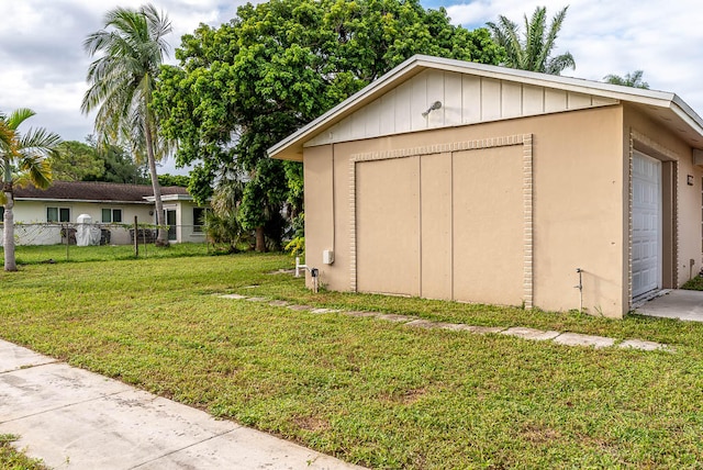 view of outbuilding with a garage and a lawn