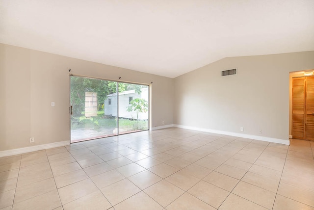 unfurnished room featuring lofted ceiling and light tile patterned flooring