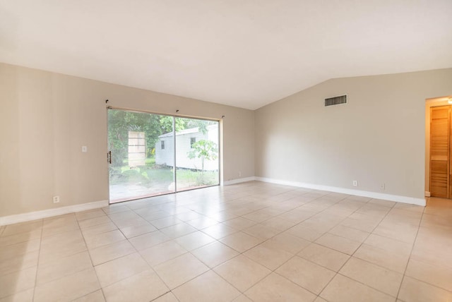 empty room featuring light tile patterned floors and lofted ceiling