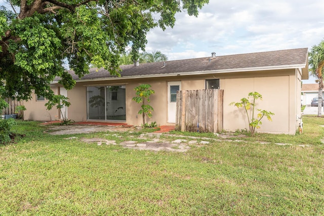 rear view of property featuring a patio area and a yard