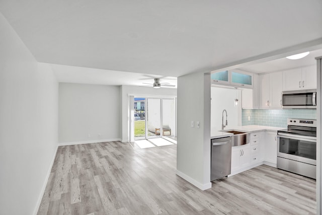 kitchen with light hardwood / wood-style flooring, stainless steel appliances, sink, white cabinets, and ceiling fan