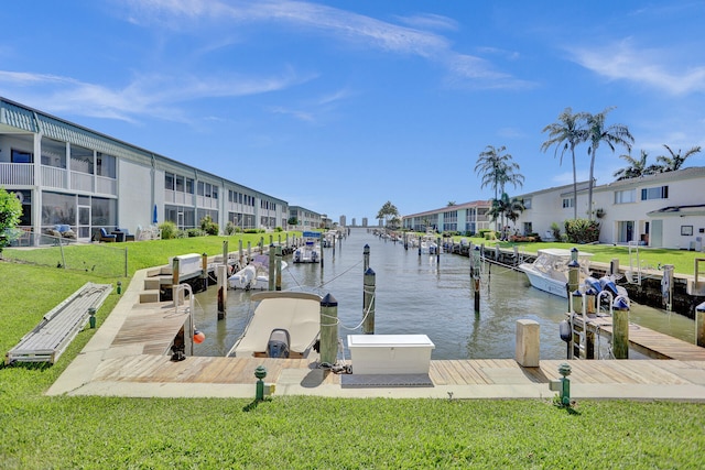 dock area with a lawn and a water view