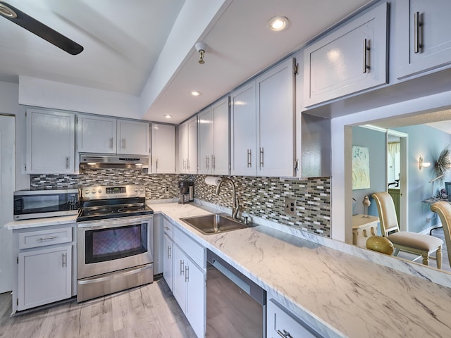 kitchen featuring decorative backsplash, stainless steel appliances, light hardwood / wood-style flooring, and sink