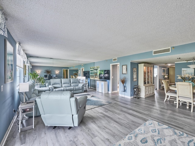 living room with wood-type flooring and a textured ceiling