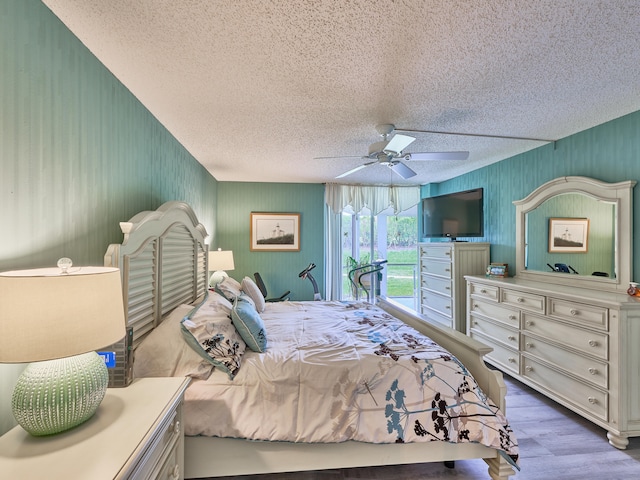 bedroom with ceiling fan, a textured ceiling, and hardwood / wood-style flooring