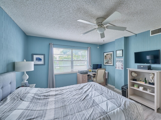 bedroom featuring a textured ceiling, light hardwood / wood-style floors, and ceiling fan