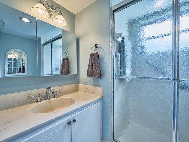 bathroom with vanity, a healthy amount of sunlight, and a shower with shower door