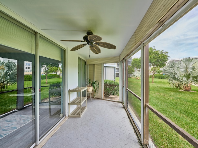 unfurnished sunroom with ceiling fan