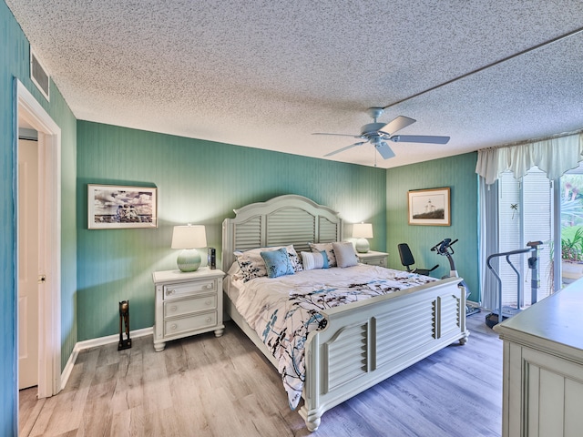 bedroom with ceiling fan, light hardwood / wood-style flooring, and a textured ceiling