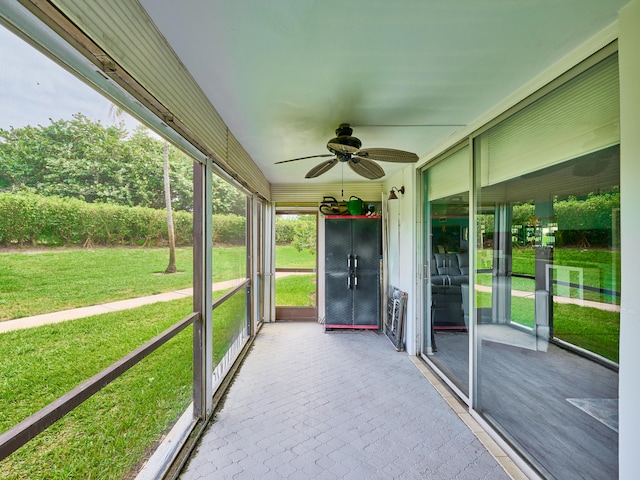 unfurnished sunroom featuring ceiling fan