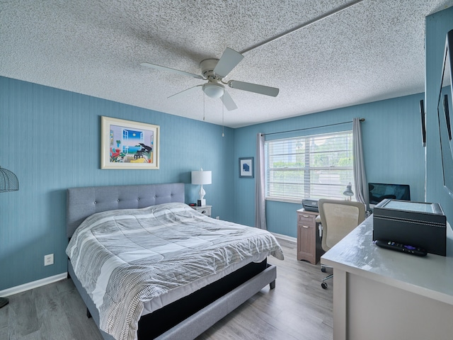 bedroom featuring wood-type flooring, a textured ceiling, and ceiling fan