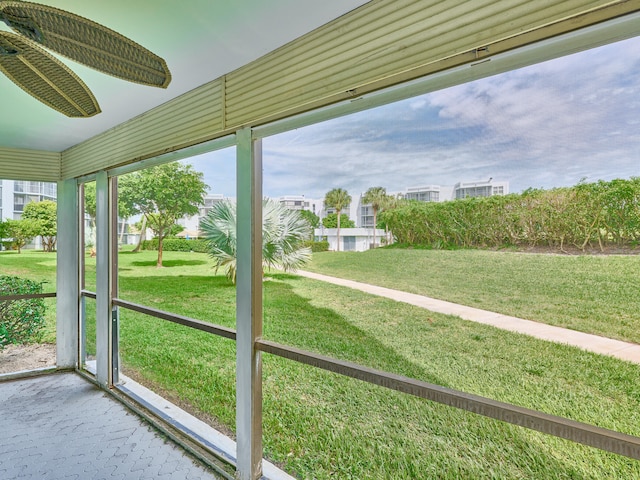 unfurnished sunroom with ceiling fan