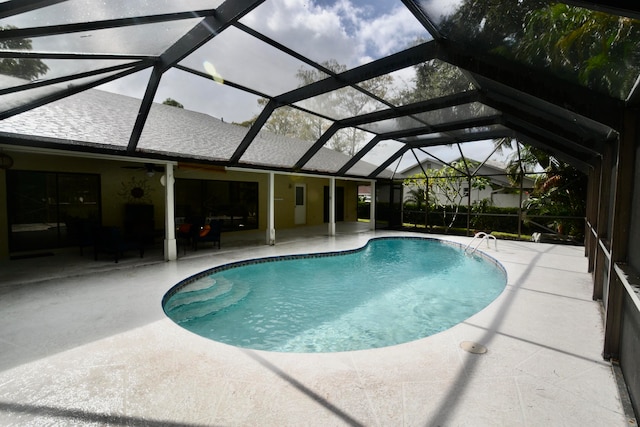 view of swimming pool featuring a patio, ceiling fan, and a lanai