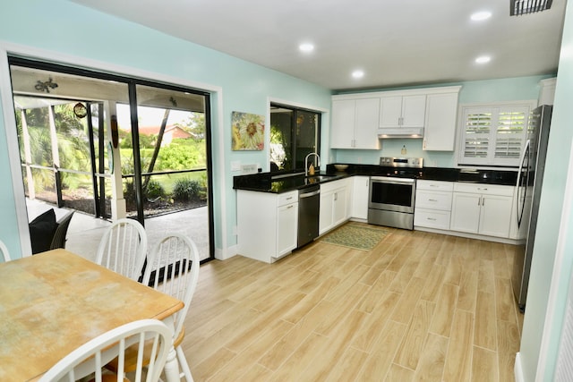 kitchen with sink, appliances with stainless steel finishes, white cabinetry, and plenty of natural light