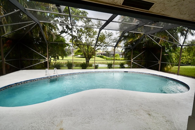 view of swimming pool featuring a water view, a patio area, and glass enclosure