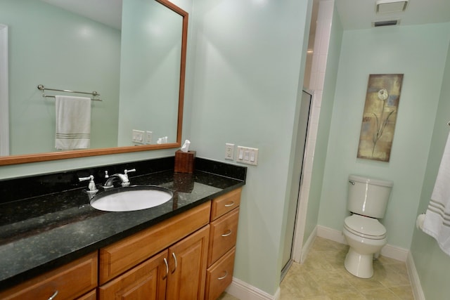 bathroom with vanity, toilet, tile patterned floors, and walk in shower