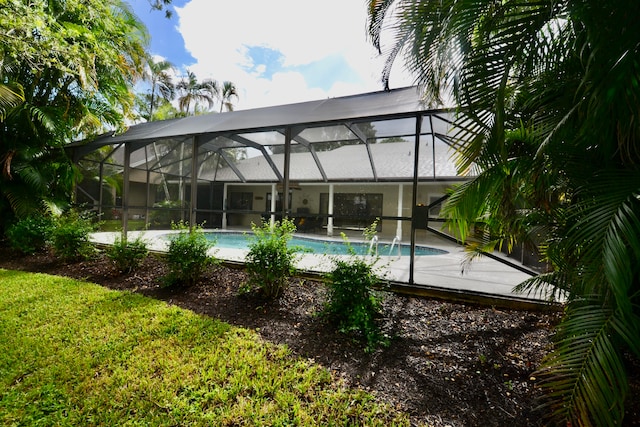 view of swimming pool with a patio area and a lanai