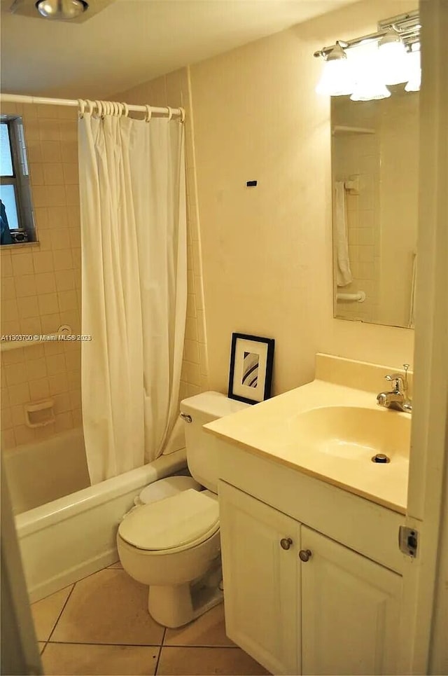 full bathroom featuring toilet, shower / bath combo with shower curtain, vanity, and tile patterned floors