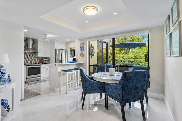 dining area with crown molding and a raised ceiling