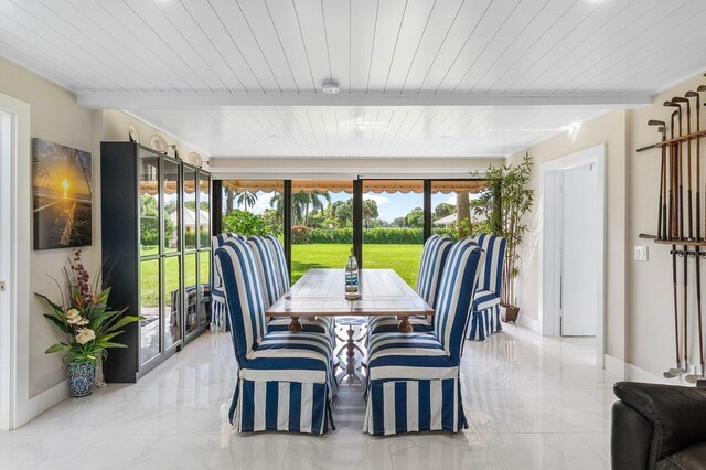 sunroom / solarium with beam ceiling, a healthy amount of sunlight, and wooden ceiling