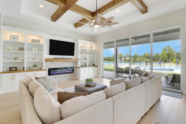 living room featuring ceiling fan, beam ceiling, light wood-type flooring, and coffered ceiling