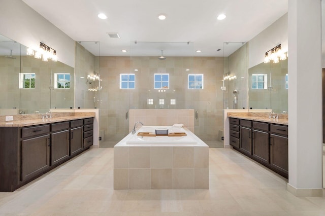 bathroom featuring a wealth of natural light, tile walls, and independent shower and bath