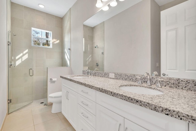 bathroom with tile patterned floors, toilet, vanity, and walk in shower