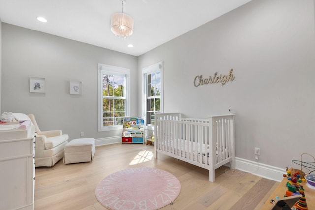 bedroom featuring light hardwood / wood-style floors and a crib