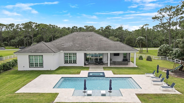 back of house with a lawn, a pool with hot tub, and a patio area