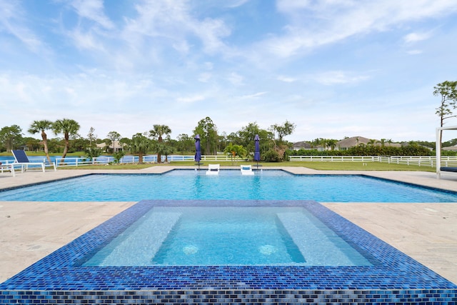 view of pool featuring an in ground hot tub, pool water feature, and a patio area