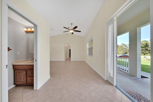 corridor with light tile patterned floors and lofted ceiling