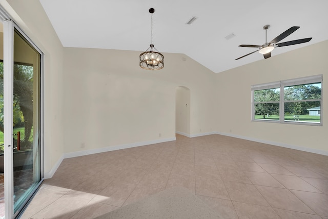 tiled empty room with lofted ceiling and ceiling fan with notable chandelier