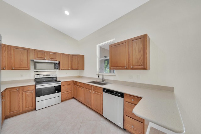 kitchen with sink, vaulted ceiling, stainless steel appliances, and light tile patterned floors