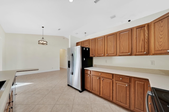 kitchen with lofted ceiling, light tile patterned floors, appliances with stainless steel finishes, pendant lighting, and a notable chandelier