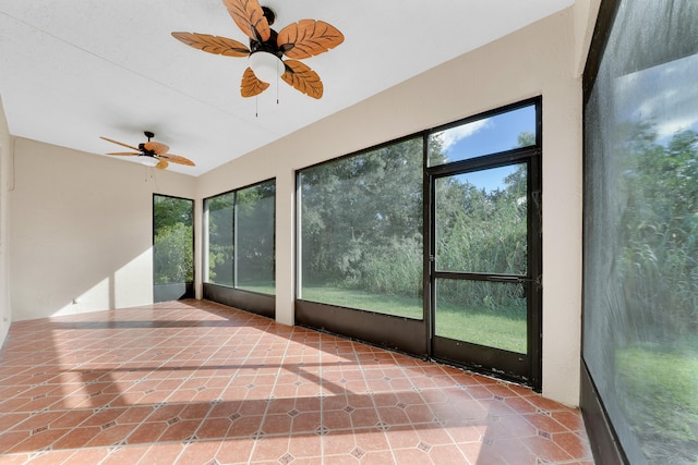 unfurnished sunroom with ceiling fan