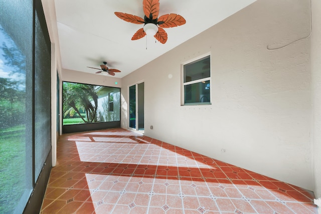 unfurnished sunroom with ceiling fan