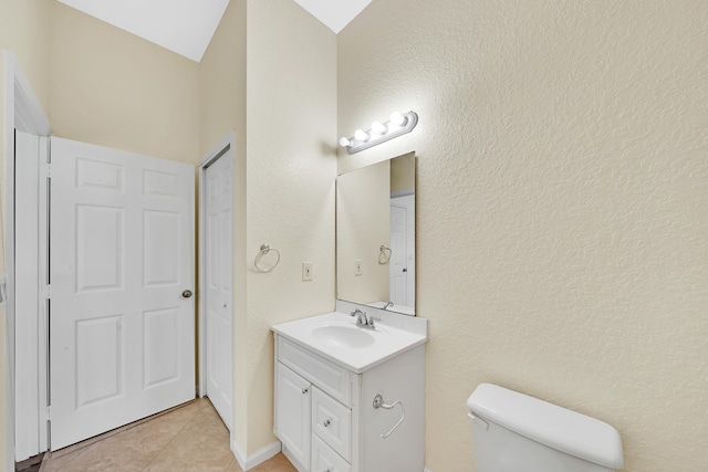 bathroom with vanity, toilet, and tile patterned flooring