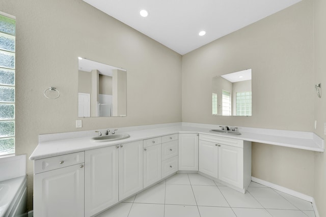 bathroom with vanity, a healthy amount of sunlight, tile patterned floors, and a bath