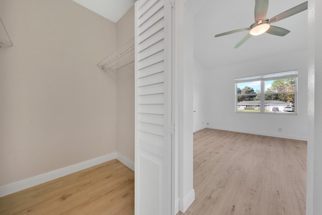 spacious closet featuring light hardwood / wood-style flooring, ceiling fan, and vaulted ceiling