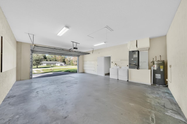 garage with water heater, heating unit, and washing machine and clothes dryer