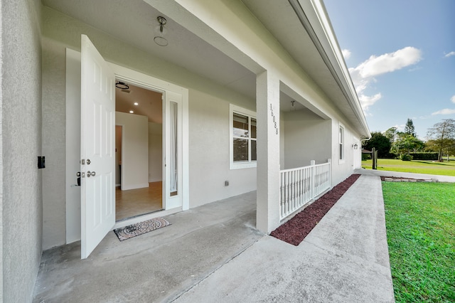 doorway to property with a patio area and a yard